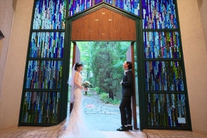 千里阪急ホテルにてチャペルの入り口に向かい合って立つ新郎新婦