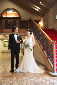 千里阪急ホテルにて階段横で微笑合う新郎新婦