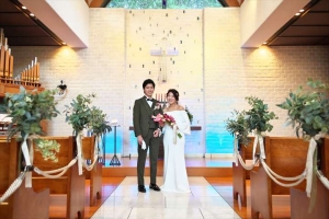 千里阪急ホテルにてチャペルでポーズを取る新郎新婦