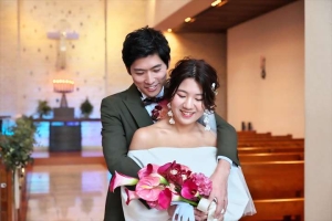 千里阪急ホテルにてブーケを見つめる新郎新婦