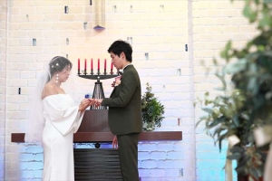 千里阪急ホテルにて指輪交換を行う新郎新婦
