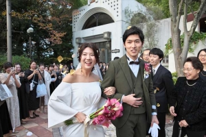 千里阪急ホテルにてフラワーシャワーの祝福を受ける新郎新婦