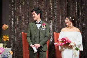 千里阪急ホテルにてメインソファ前に立つ新郎新婦