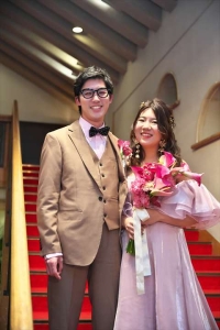 千里阪急ホテルにて階段前に立って微笑む新郎新婦