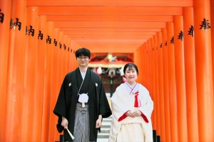 生田神社にて鳥居の中に立って微笑む新郎新婦
