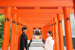 生田神社にて鳥居の中で向かい合って立つ新郎新婦