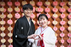 生田神社にてハートマークを作ってほほ笑む新郎新婦