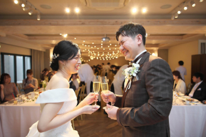 TOAST(旧北野クラブ ANNEX)にて向かい合ってシャンパングラスで乾杯をする新郎新婦