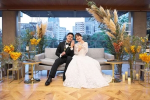 THE SORAKUENにてメインソファに座って指輪を見せる新郎新婦