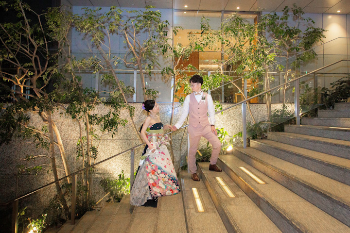 ロサンジェルスバルコニーでの披露宴後に階段で手を取り合う新郎新婦