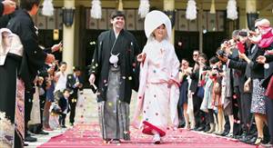 ゲストから紙吹雪の祝福を受ける新郎新婦の当日スナップ写真