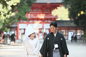 下鴨神社で手をつないで歩いている新郎新婦の写真