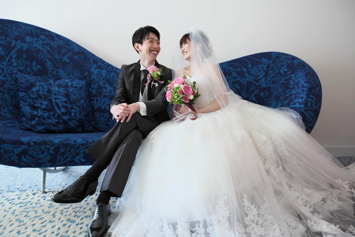 神戸メリケンパークオリエンタルホテルのソファーで会話をする新郎新婦