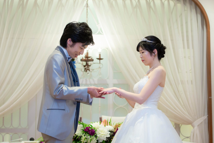 アンフェリシオンでの結婚式で指輪を交換する新郎新婦