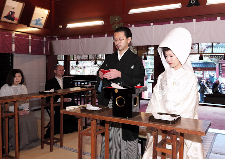 根津神社での神前式で三三九度をする新郎新婦