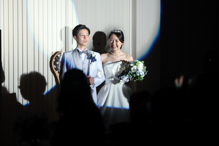 結婚式持ち込みカメラマンが撮影：スポットライトを浴びて笑顔になる新郎新婦